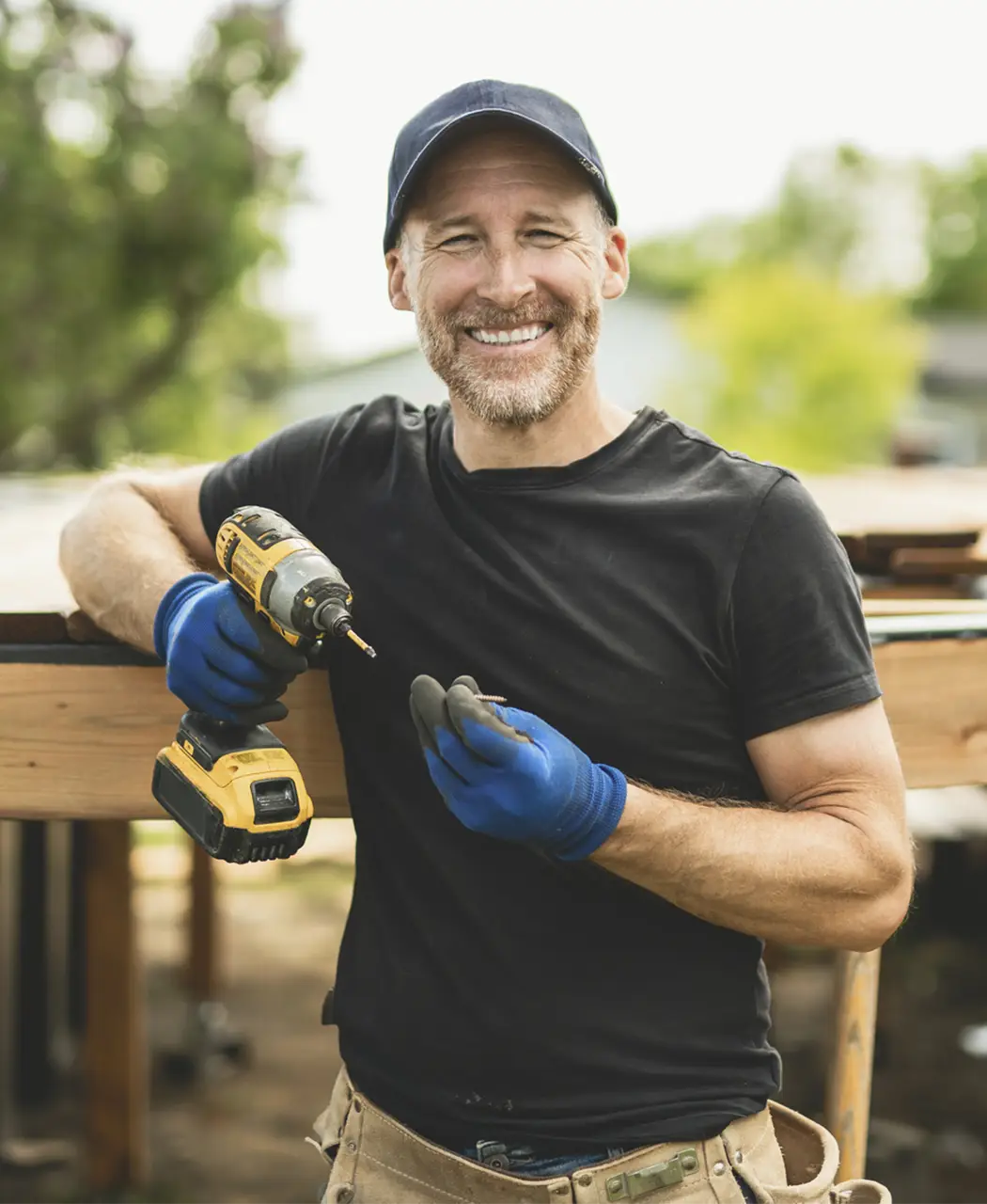 deck-builder-iStock-2235913003 photo of a smiling contractor changing his drill bit